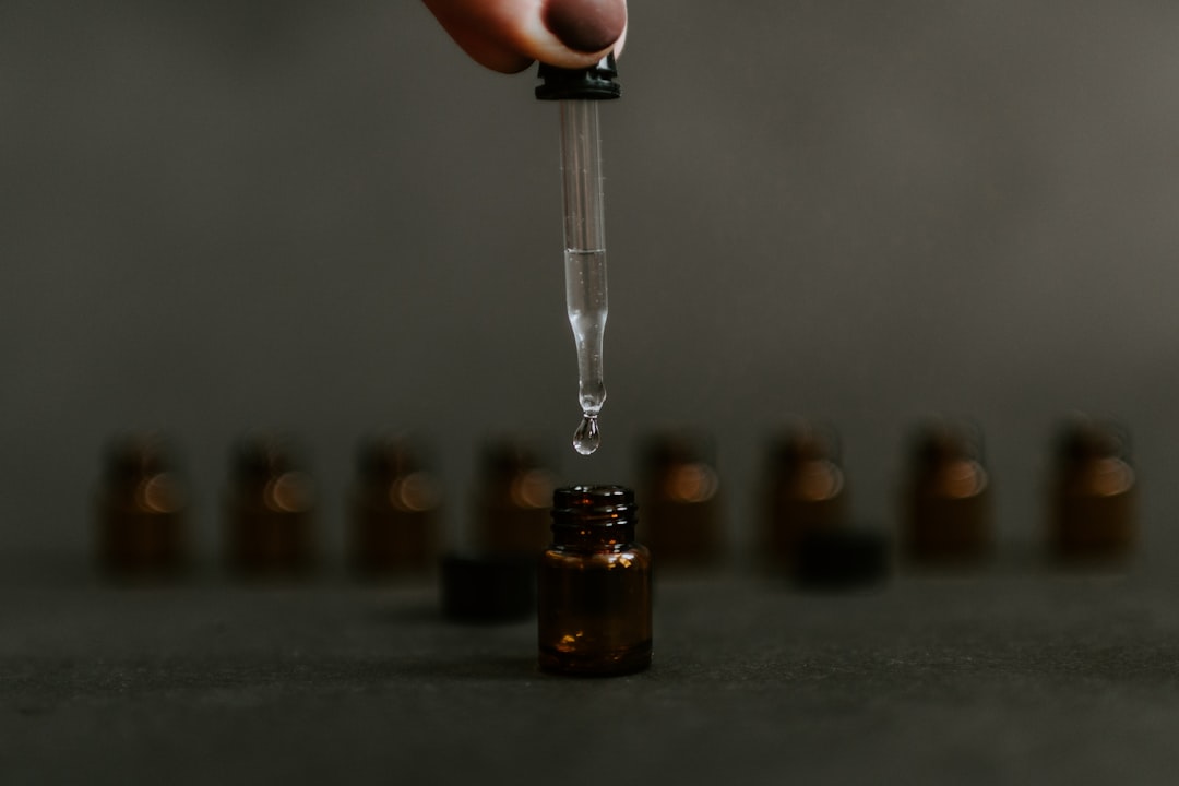 A Pipette filling a small bottle with Essential Oil