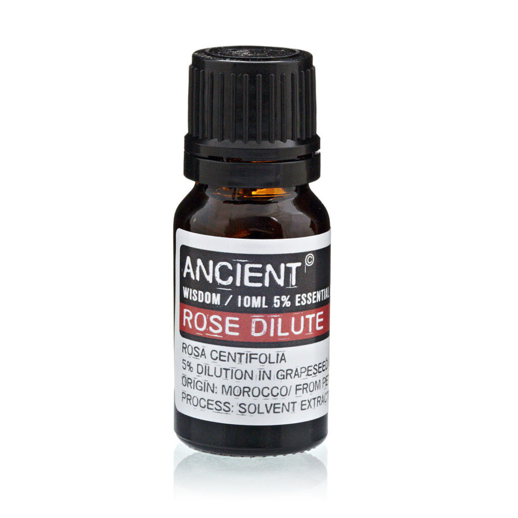 Amber essential oil bottle with black ribbed cap; label reads 'ANCIENT WISDOM' and 'ROSE DILUTE' (rose essential oil).